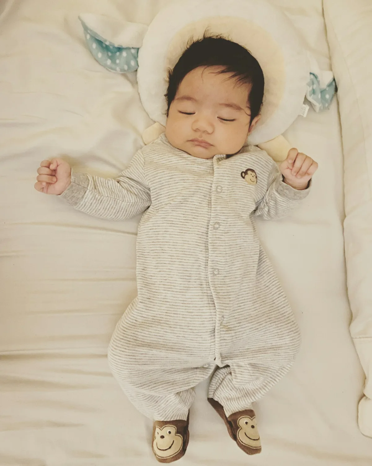 布団の上であおむけに眠っている赤ちゃん