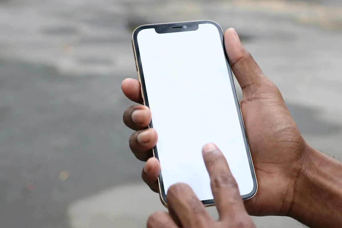 両手でスマートフォンを持って画面を操作している手元（顔は写っていない）