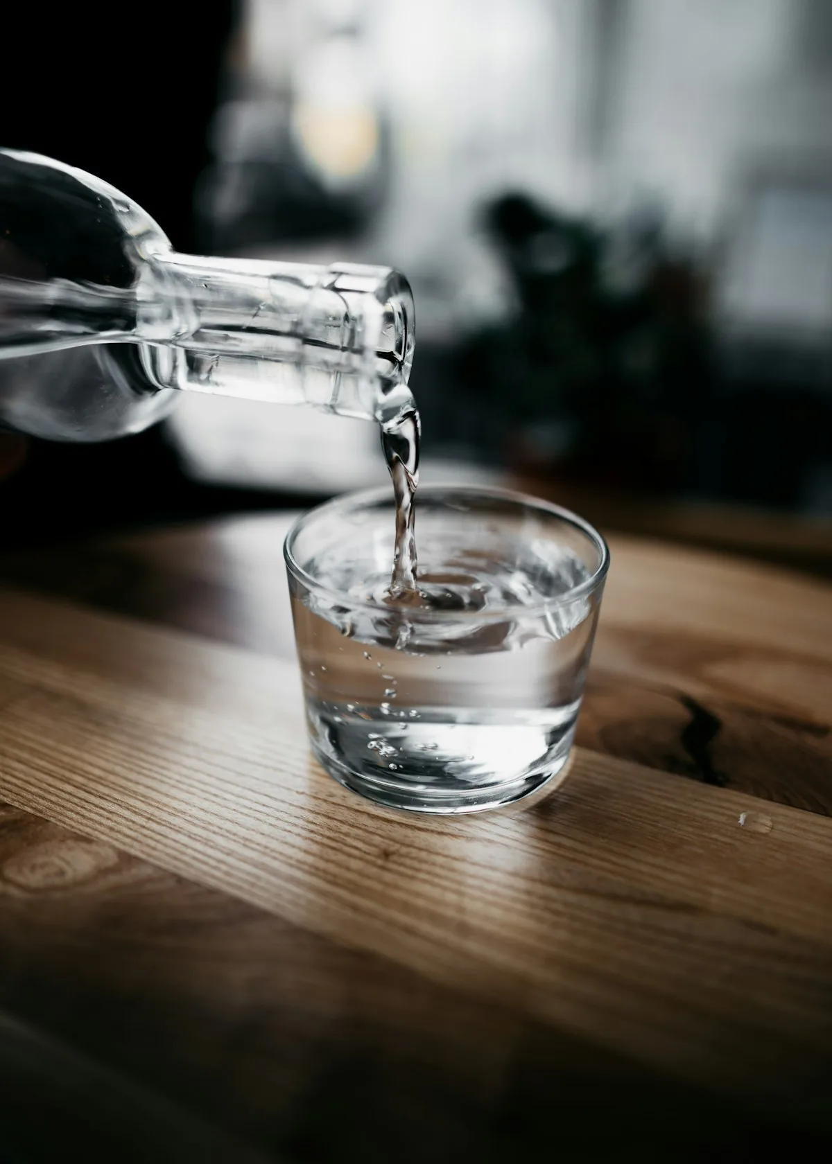 ボトルからグラスに水が注がれている