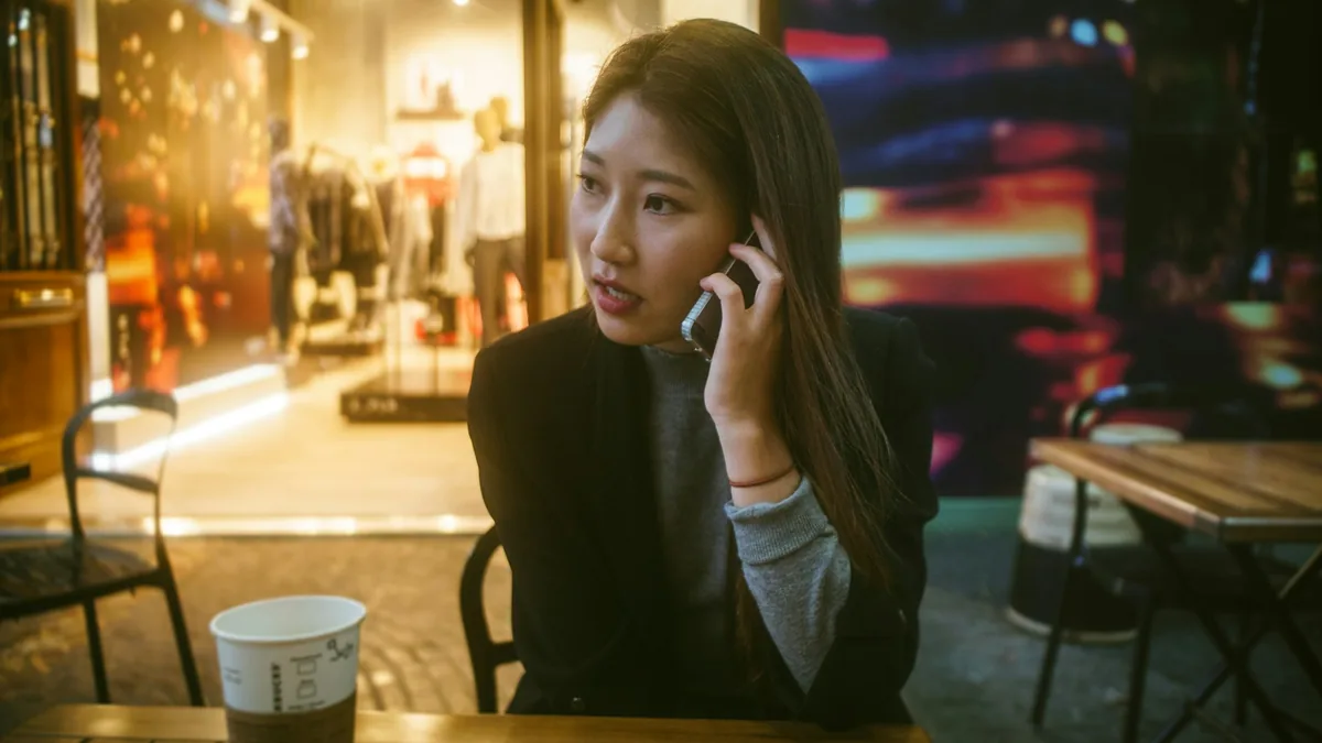 屋外で携帯電話で話している女性