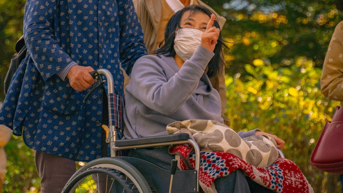 車いすの高齢者に家族が付き添う