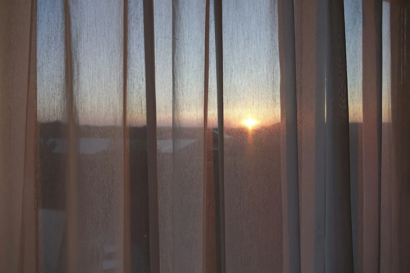 カーテン越しに見る夕方の空
