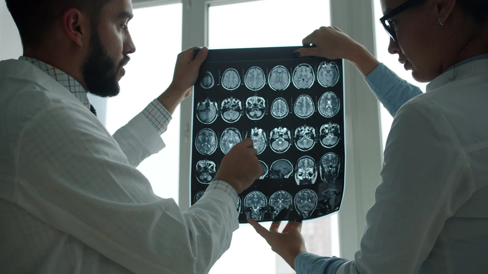 医師が2人、CT・MRIの脳画像を並べて確認している様子