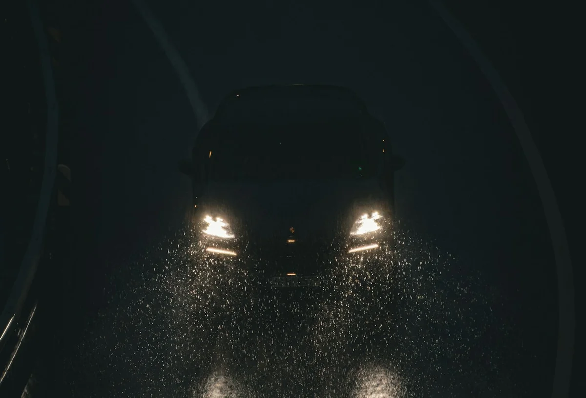 雨の夜、ヘッドライトが照らす路面