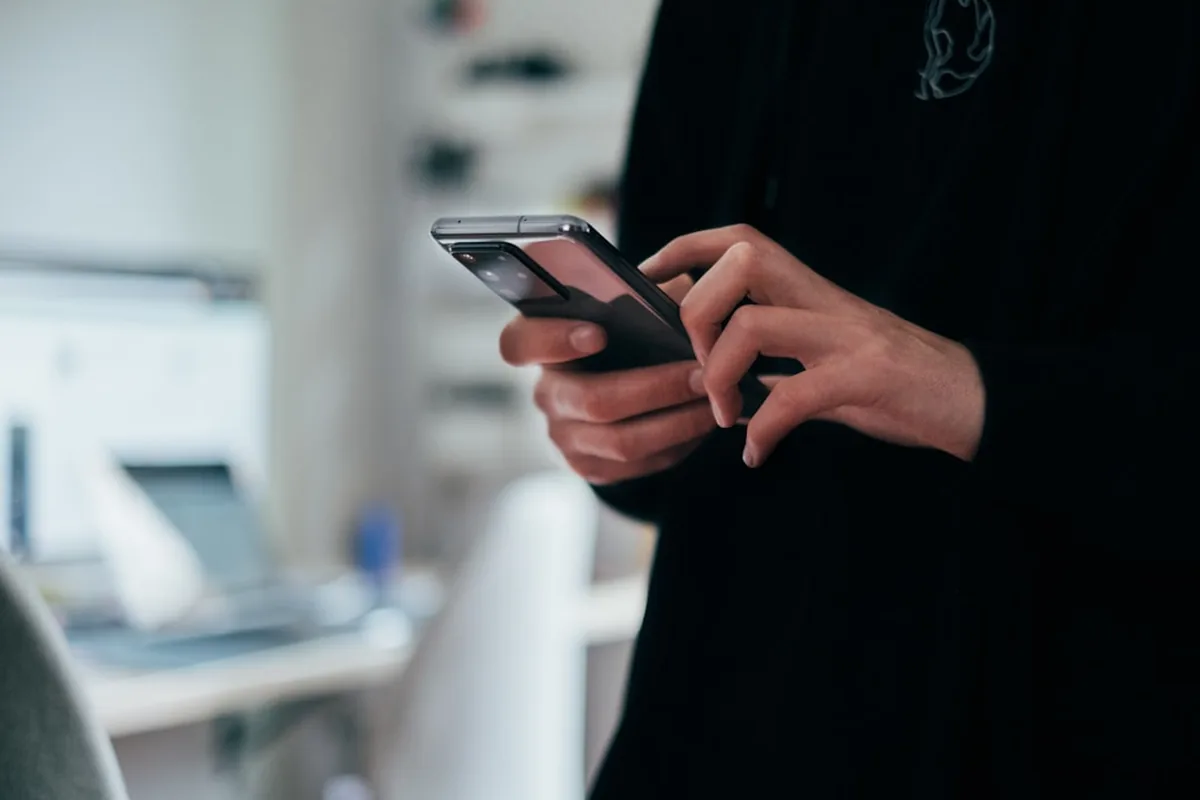 スマートフォンでメッセージアプリを操作する手元