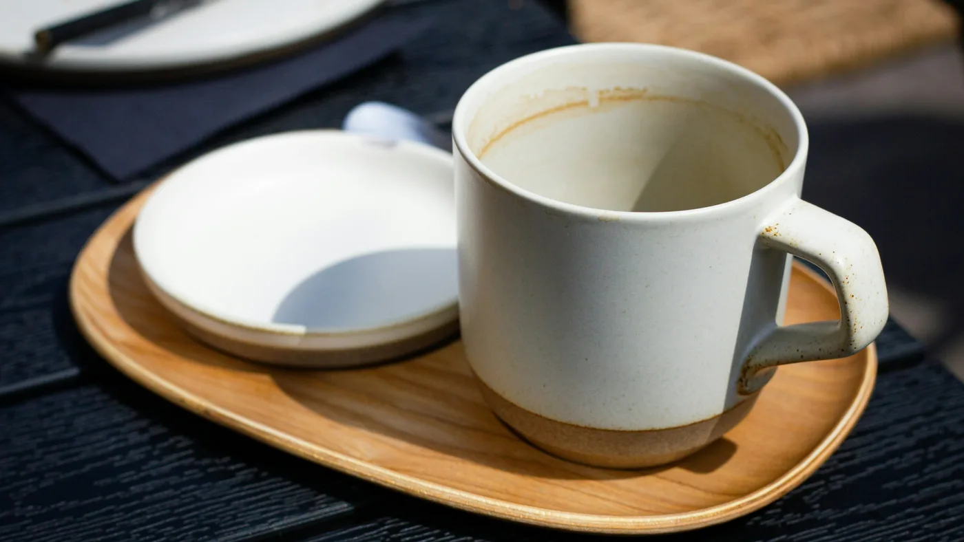 木のトレイに置かれた、飲み終えたマグカップと小さな器