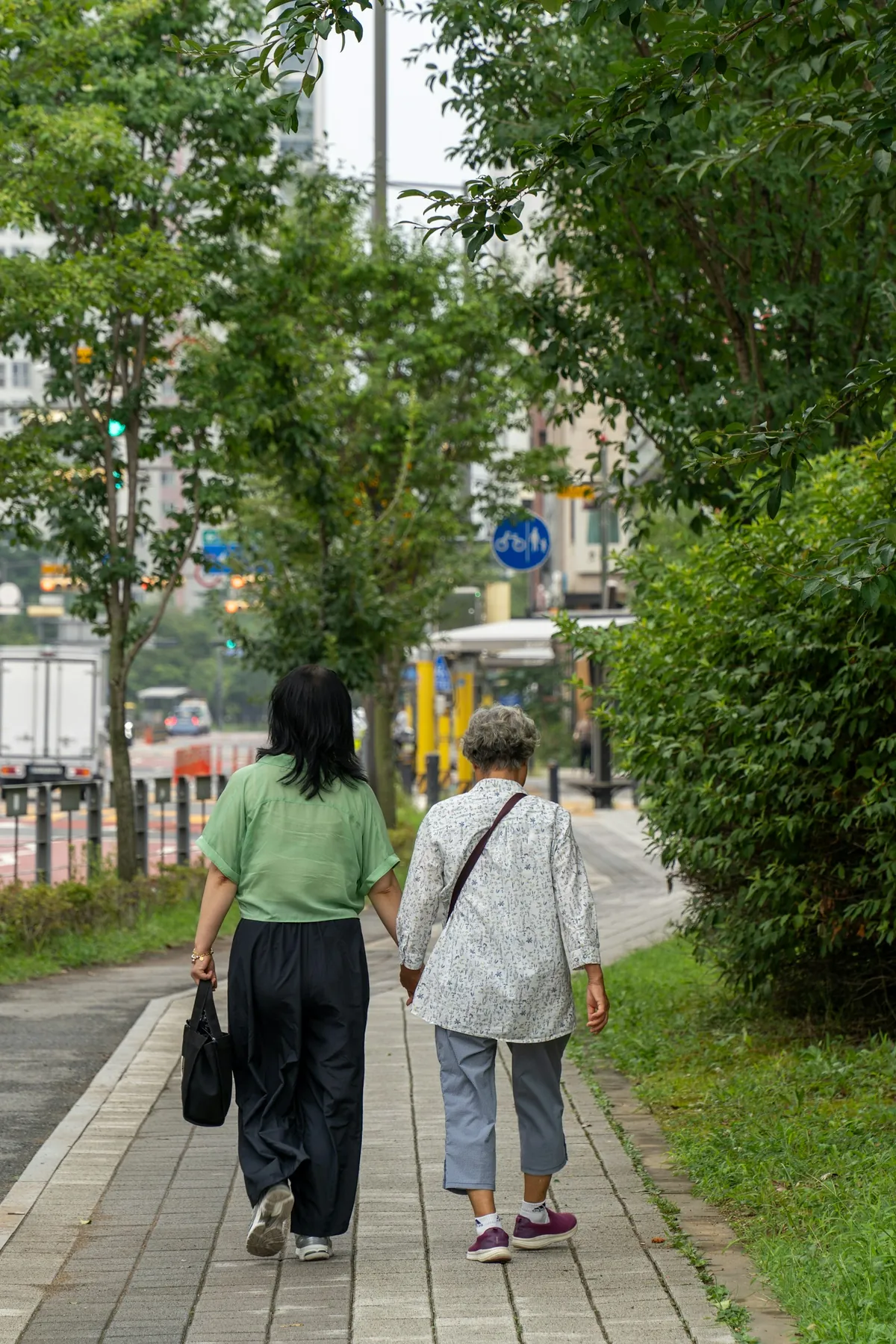 手をつないで並んで歩く母娘の後ろ姿