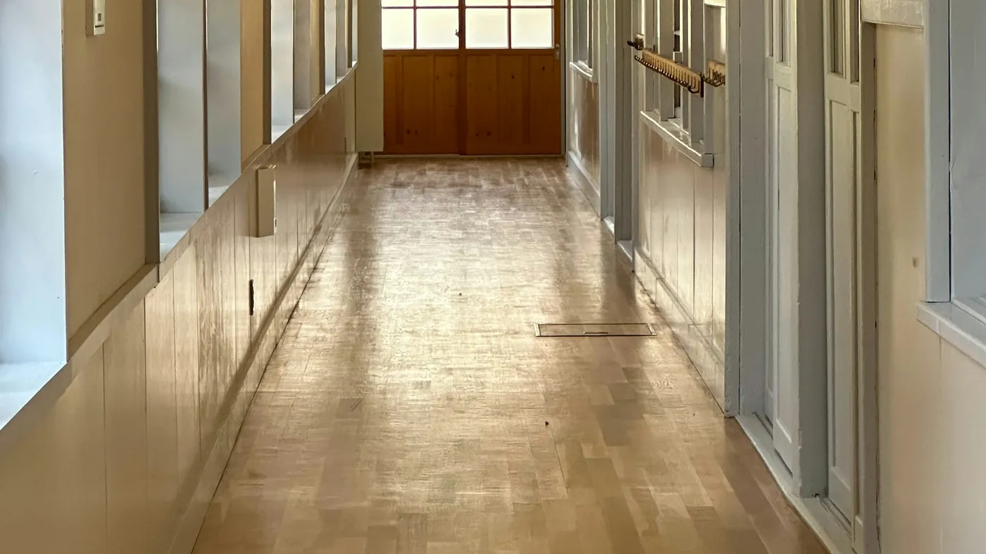 窓と木の扉のある、無人の建物の廊下