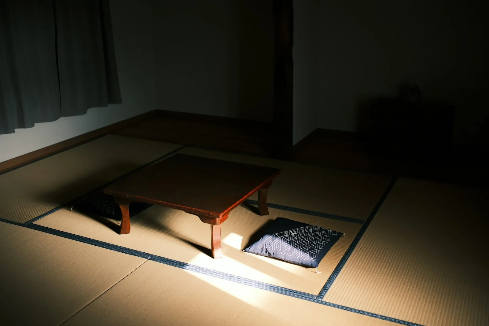 日の差し込む和室に置かれた低いちゃぶ台と座布団