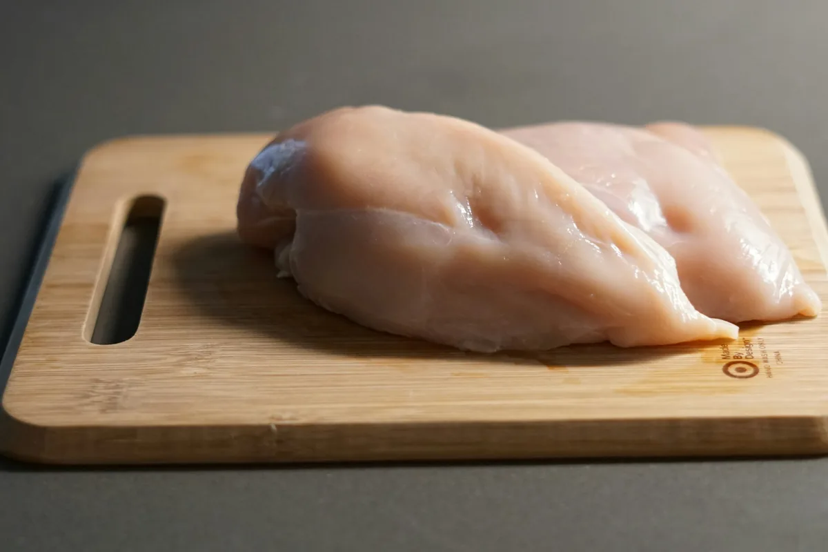 まな板の上に置かれた生の鶏肉
