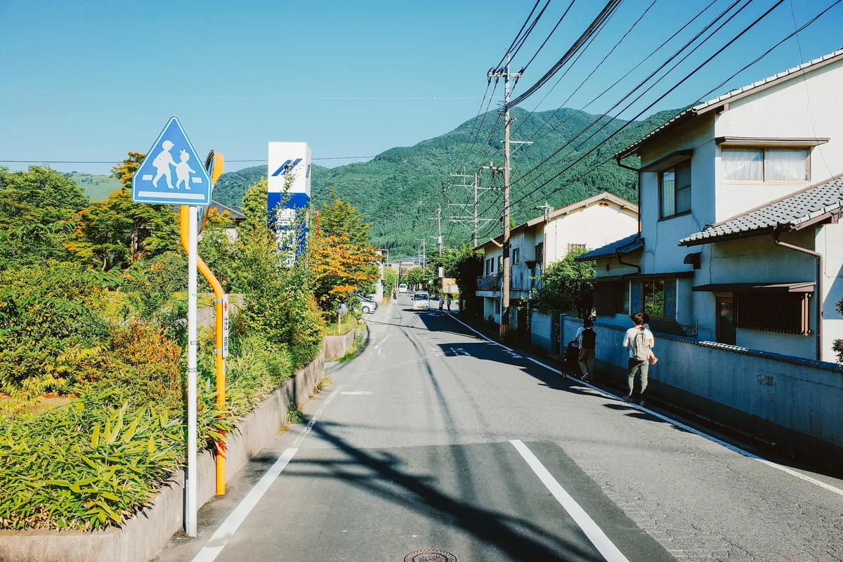 青空の下、日差しが照りつける日本の住宅街の坂道