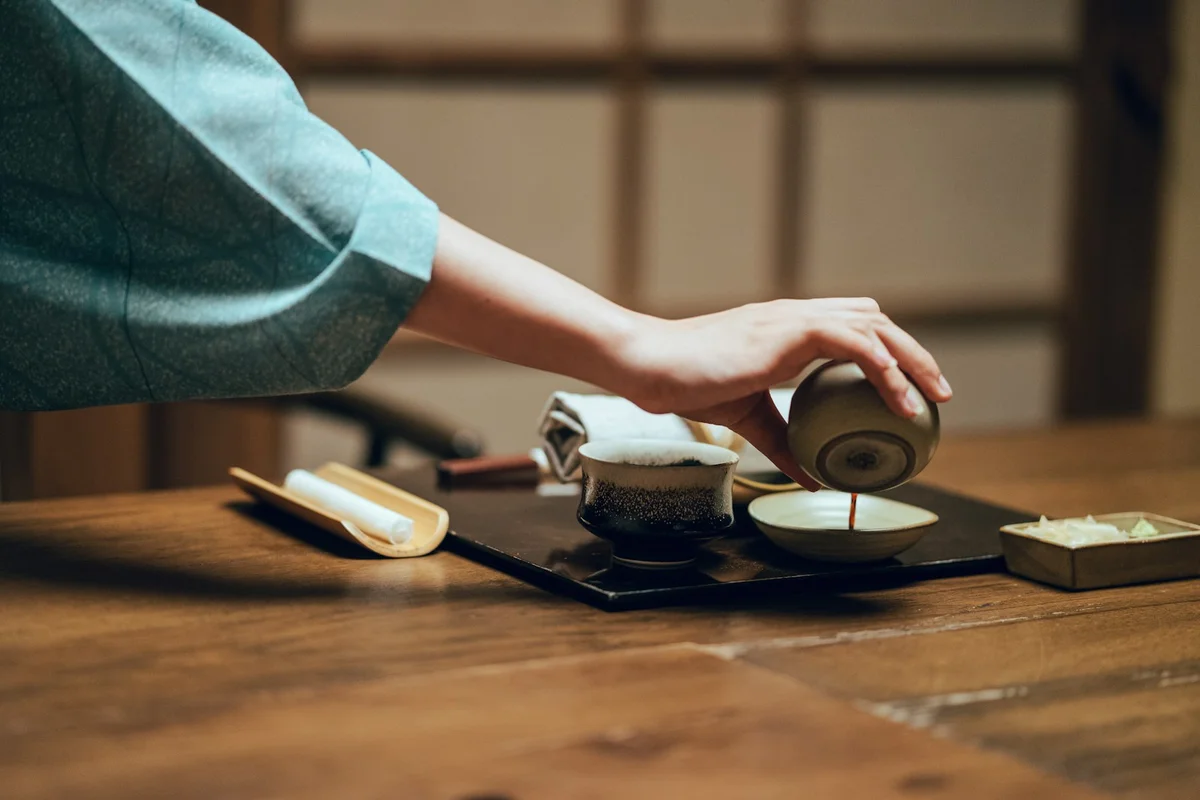 和室で急須からお茶を注いでいる手元