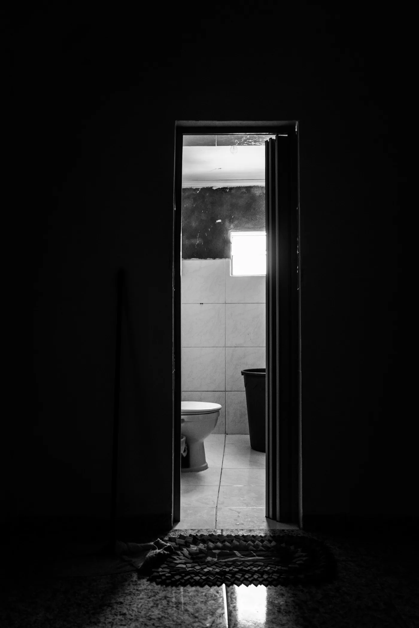 閉じられた木のドアの向こうに、白いトイレが見える