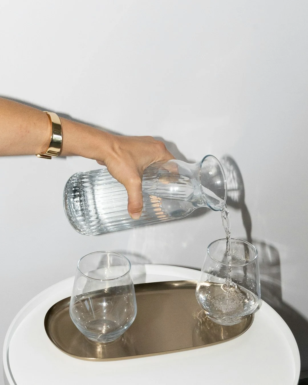 ピッチャーから水を注ぐ手元