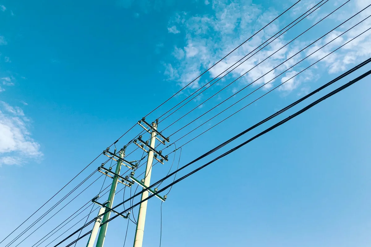 青空にのびるコンクリートの電柱と電線