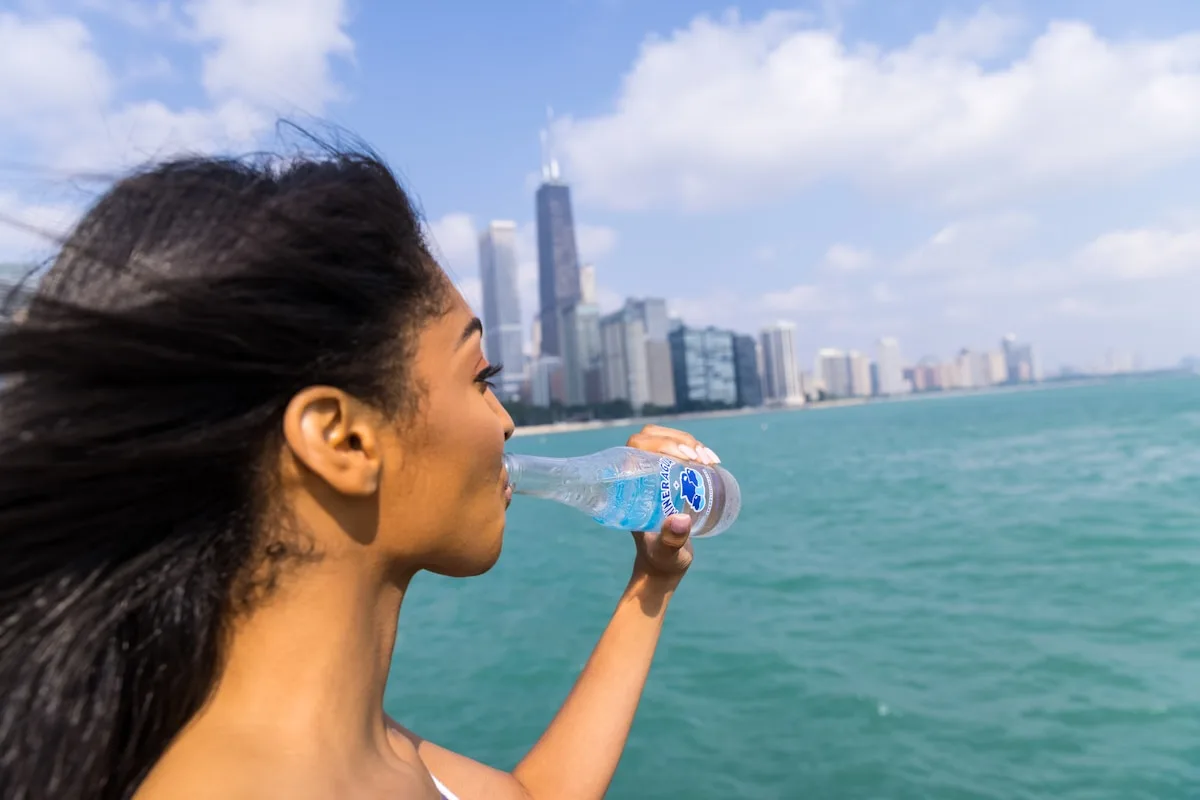 水のボトルを飲む女性。自分で飲める状態なら少量ずつこまめに水分補給することが大切