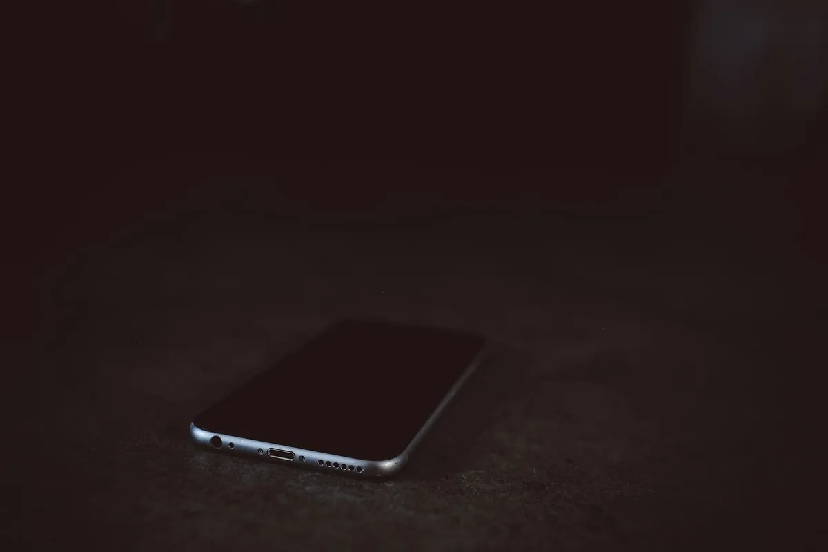 夜、暗い机の上に置かれたスマートフォン