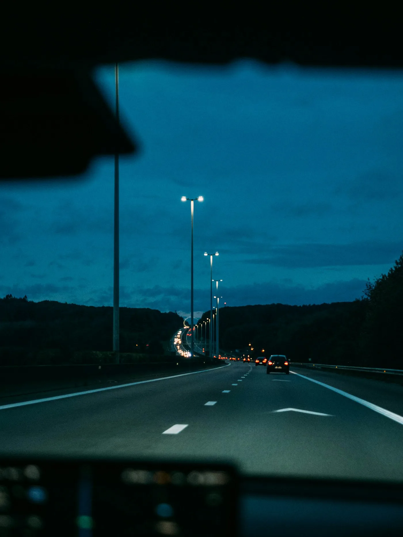 車のフロントガラス越しに見える夜の道路