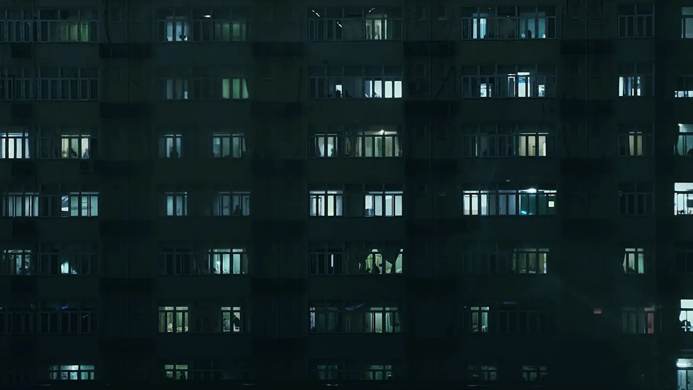 夜、たくさんの窓に明かりがついている建物