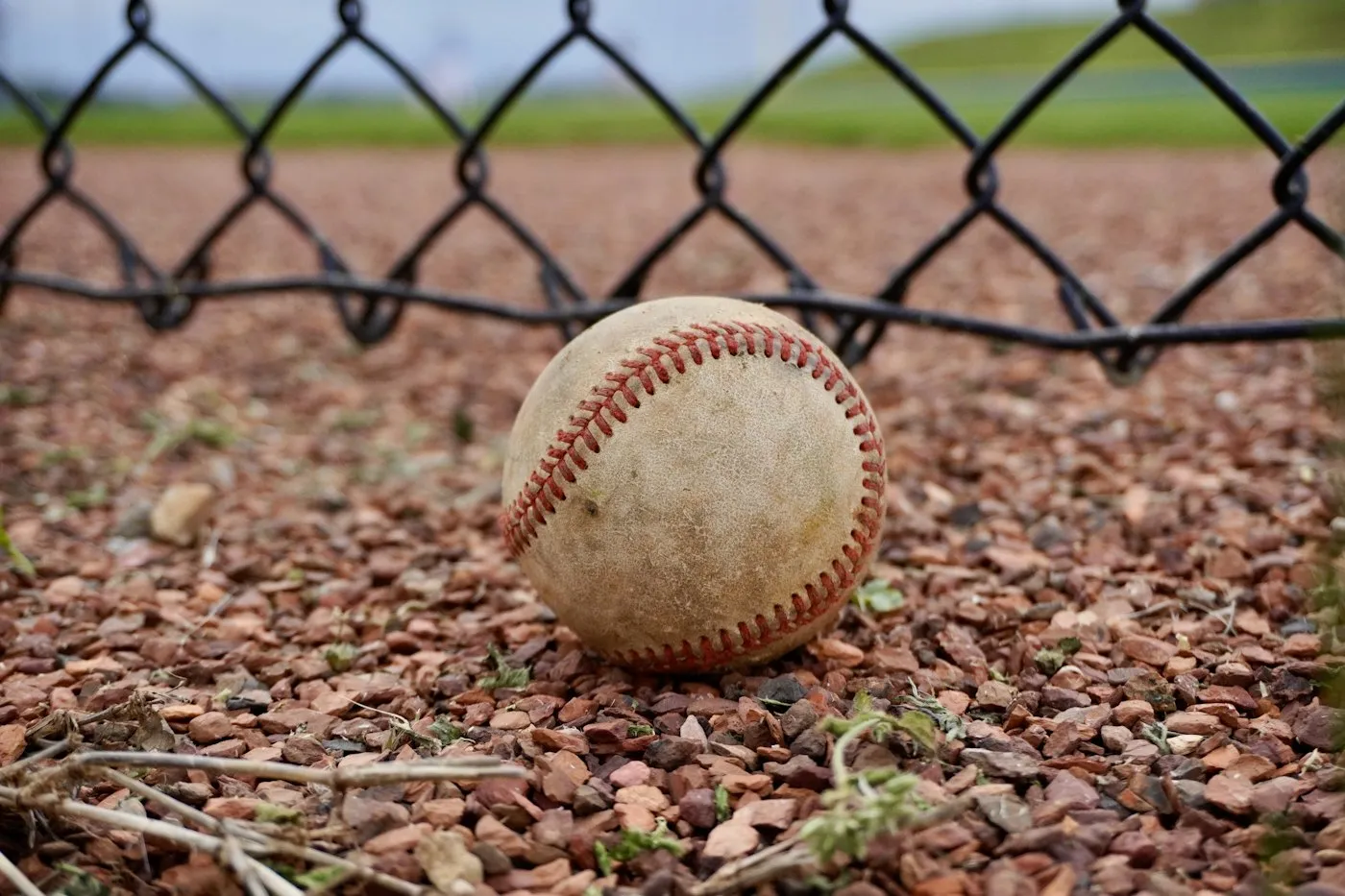 フェンス際の砂利の上に置かれた野球のボール