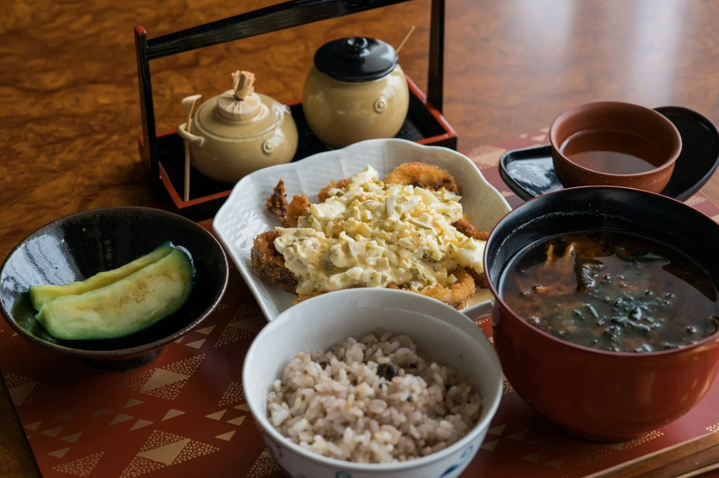 和食の一汁三菜。ごはん、味噌汁、揚げ物、漬物が朱塗りの膳にのっている